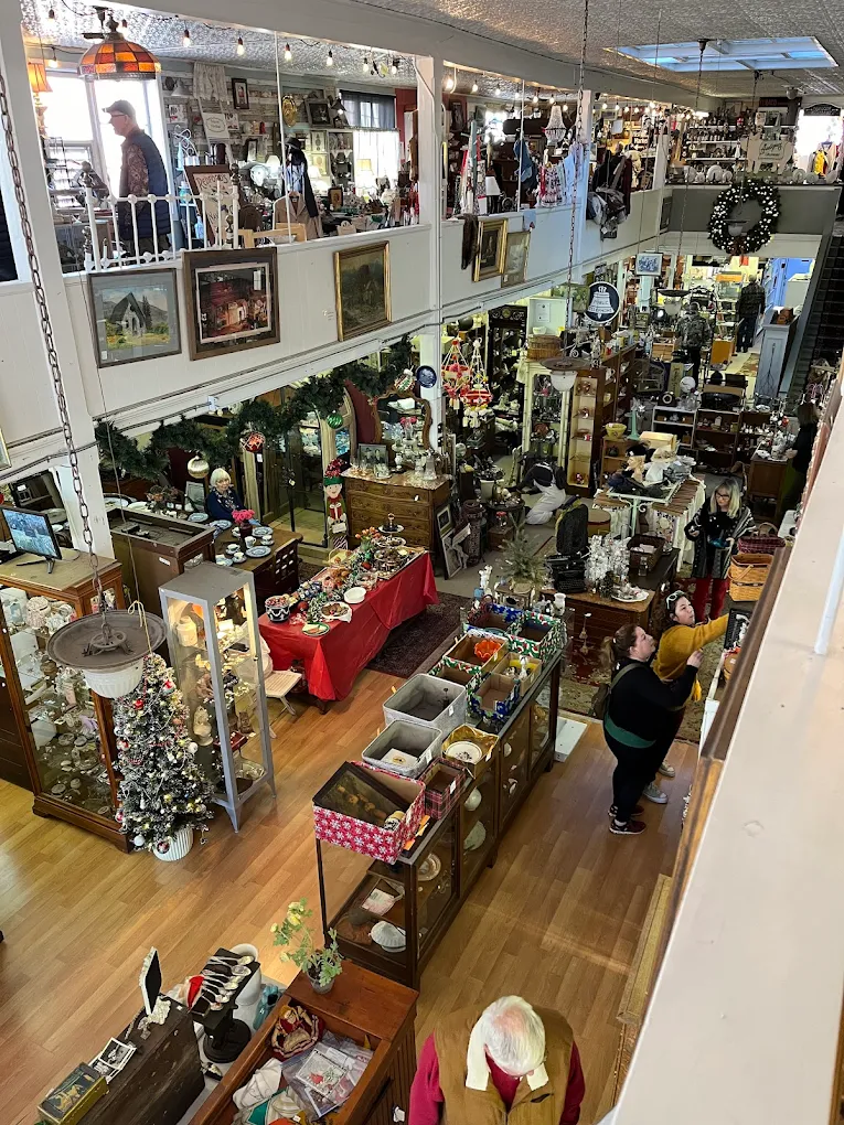 Busy indoor market with various stalls and shoppers.