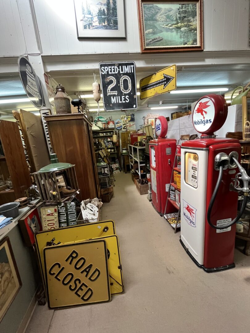Vintage gas pumps and road signs in an antique store.