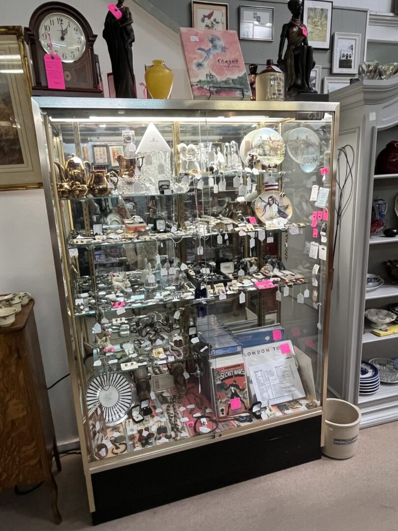 Glass display case filled with various jewelry and decorative items.