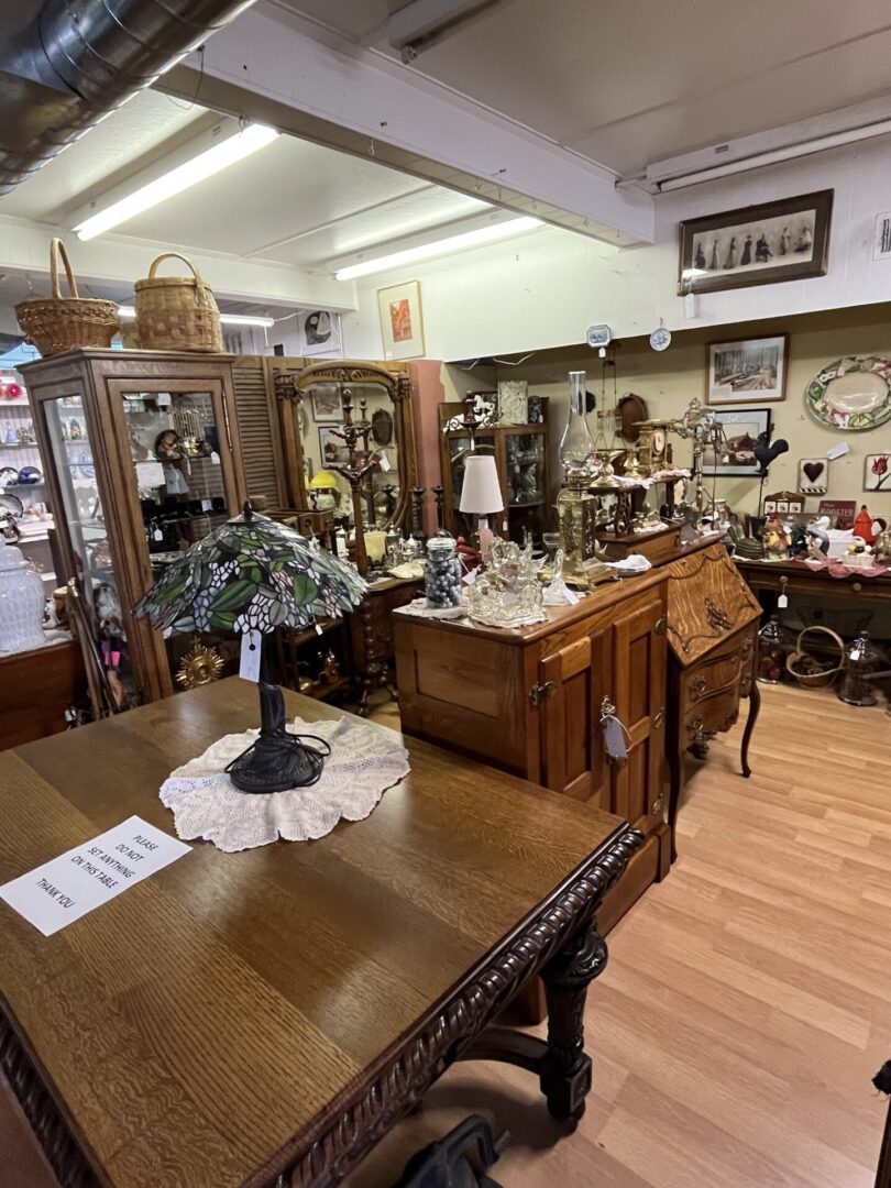 Antique furniture and decor fill a cozy vintage shop interior.